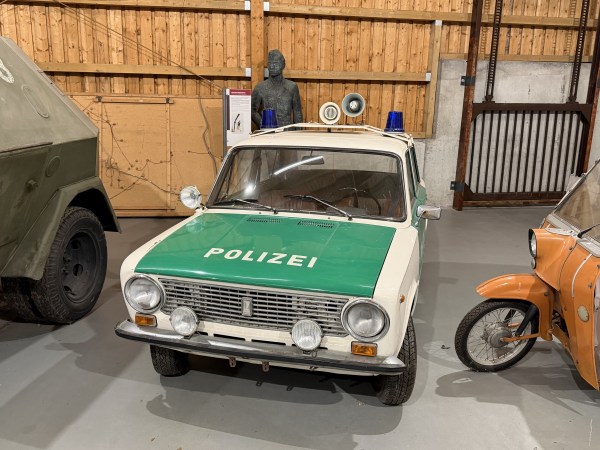 Lada v barvě zelené/vajíčkové skořápky se 2 modrými světly a interkomem jako policejní vozidlo. Na kapotě je nápis Police v barvě vaječné skořápky.