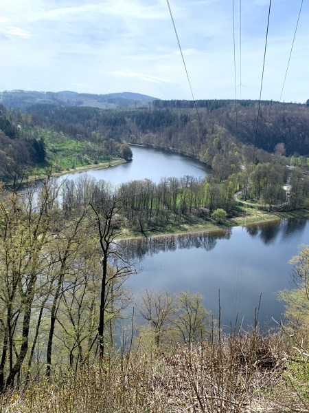 Vodní oblouk uprostřed zalesněné krajiny